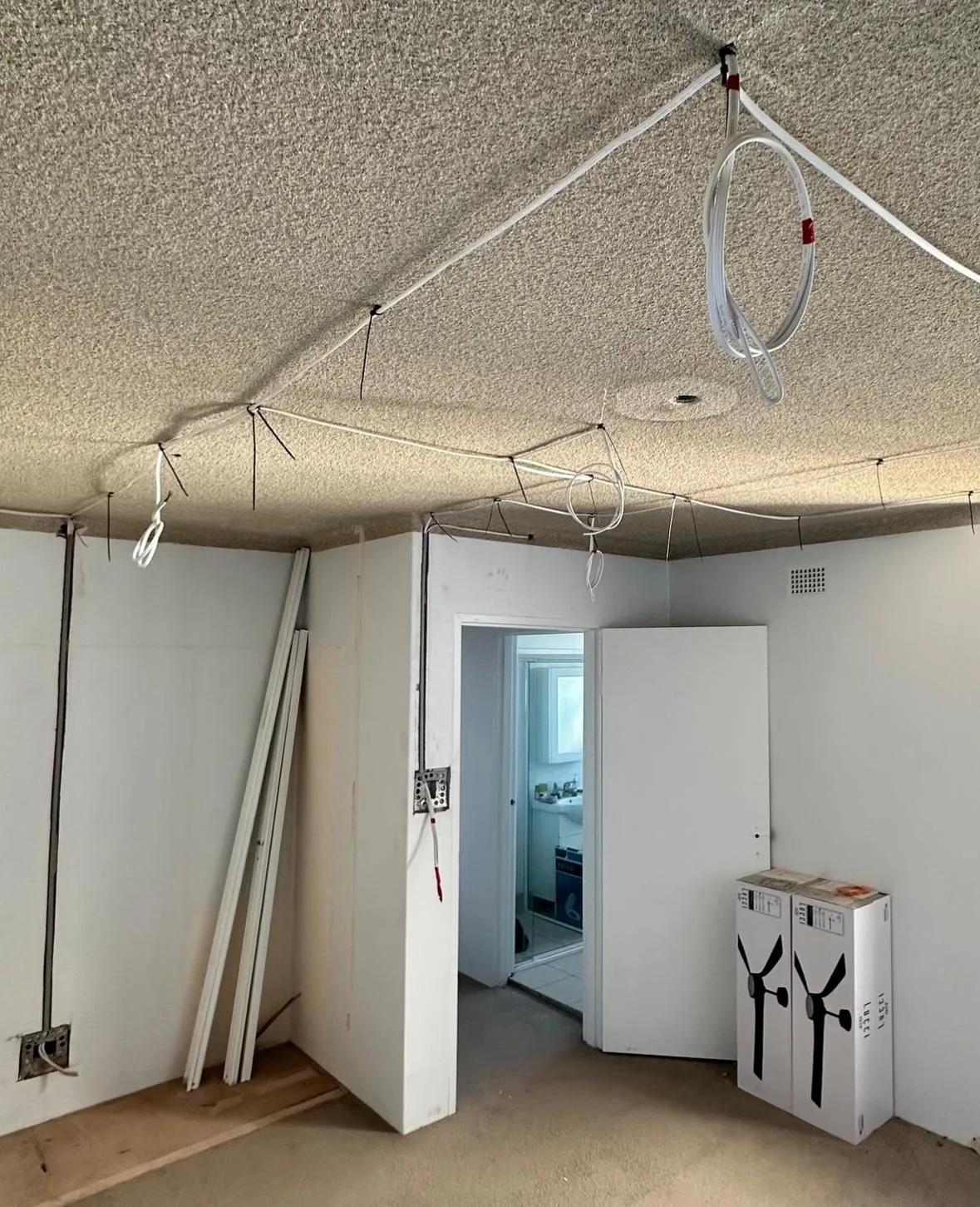 Residential wiring installation in progress with ceiling cables at a home renovation site in Sydney